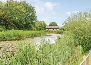 a river with a building in the middle of a field at Oakwood Lodges in Skipwith