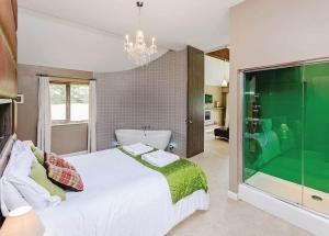 a bedroom with a large white bed and a bath tub at Oakwood Lodges in Skipwith