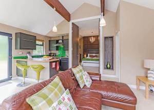 a living room with a brown leather couch and a kitchen at Oakwood Lodges in Skipwith