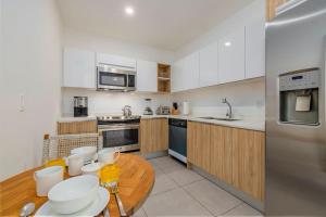a kitchen with white cabinets and a wooden table at Hh-3Bs612 - Amazing Beach Condo Oceanfront In Aruba! in Oranjestad