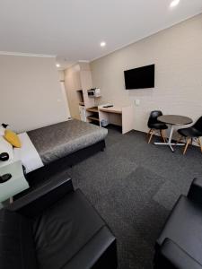 a hotel room with a bed and a flat screen tv at Central Deborah Motel in Bendigo