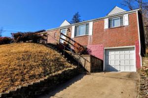 a brick house with a white garage door at King Bed! Quiet Pittsburgh Home! Close to City! in Pittsburgh