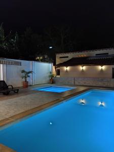 uma piscina iluminada à noite com luzes azuis em Hotel Finca Recreacional La Fortaleza 