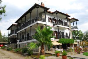 a building with a palm tree in front of it at Elia Apartments Sithonia in Elia