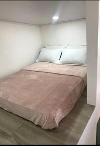 a large bed in a white room with avertisement at Loft Alajuela in Alajuela City