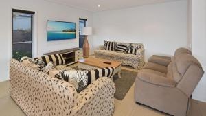 a living room with two couches and a television at Luxury waterfront house close to Theme Parks and shops in Gold Coast