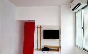 Habitación con TV de pantalla plana en la pared en Matianellu Hostel, en Río de Janeiro