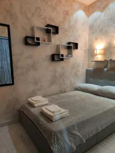 a bedroom with a bed with two towels on it at Roma Grey Suite in Rome
