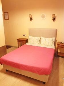 una camera da letto con un grande letto con una coperta rosa di Residencia Vale Formoso a Porto