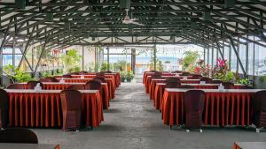 a row of tables and chairs in a building at Sun In Pangandaran Hotel in Pangandaran