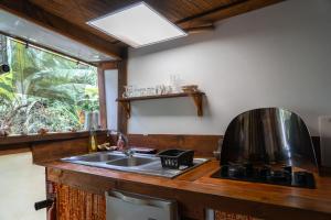 cocina con fregadero y ventana en Le Charme Polynésien proximité plage et commerces en Punaauia