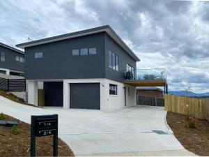 uma casa grande com um sinal em frente em Albatross Rise - Modern Family Home em Hobart