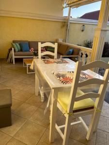 une table et des chaises sur une terrasse avec un canapé dans l'établissement Les Capucines, à Saint-Pierre