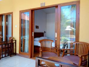 a room with a room with a bed and a glass door at Yellow Bridge Guest House in Nusa Lembongan