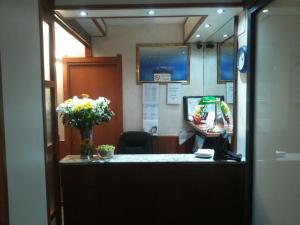 an office with a reception desk with a vase of flowers at Hotel Le Querce in Milan