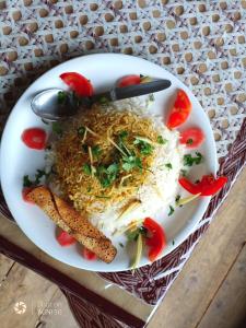 Tirthan Ecostay في Gushaini: طبق من الطعام مع الرز والخضار على الطاولة