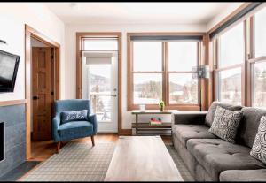 a living room with a couch and a chair at Suites sur Lac Superieur-Mont-Tremblant in Lac-Superieur