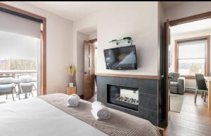1 dormitorio con chimenea y TV encima. en Suites sur Lac Superieur-Mont-Tremblant en Lac-Superieur