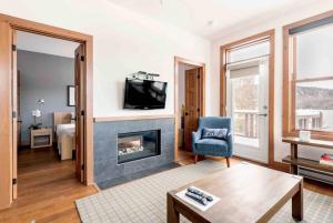 a living room with a fireplace and a tv at Suites sur Lac Superieur-Mont-Tremblant in Lac-Superieur +19 photos
