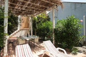 a patio with a table and chairs and a pergola at Come In Sicily La Pietra Monaca in Acireale