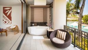 y baño con bañera y silla en el balcón. en InterContinental Fiji Golf Resort & Spa, an IHG Hotel, en Natadola