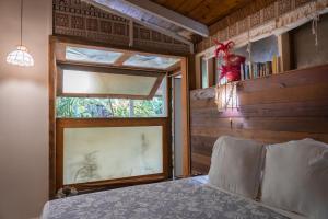 Le Charme Polynésien proximité plage et commerces في بوناويا: غرفة نوم مع نافذة وسرير في غرفة