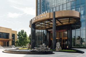 ein Gebäude mit einem Brunnen davor in der Unterkunft White Swan Guest House MeiZhou in Meizhou