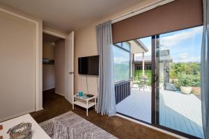 a living room with a large sliding glass door with a balcony at Golfer's Retreat in Kaikoura