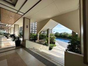 an empty lobby of a building with a view of a pool at Alea Residences in Manila