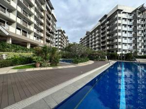 a swimming pool in front of some apartment buildings at Alea Residences in Manila