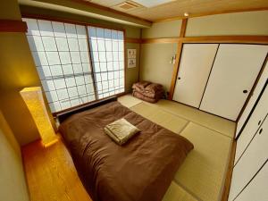 una piccola stanza con un letto e una sedia di Hotel EL 8（宇都宮駅東口） a Utsunomiya