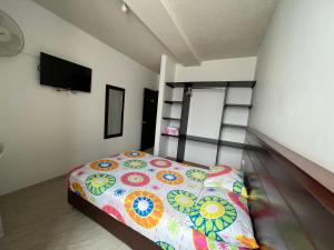 um pequeno quarto com uma cama e uma escada de beliche em Hotel Marialu em Ocaña