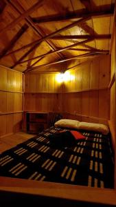 Cette chambre comprend un lit dans un dortoir doté d'un plafond en bois. dans l'établissement Tipis Ya', à San Pedro de la Laguna