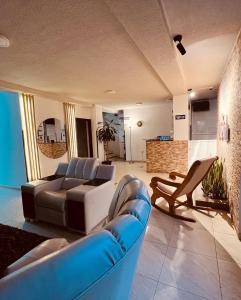 ein Wohnzimmer mit einem Sofa und Stühlen in der Unterkunft Hotel Marialu in Ocaña