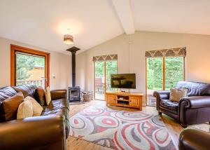 a living room with couches and a flat screen tv at Meadows End Lodges in Cartmel