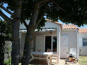 een wit huis met een tafel en stoelen en een fiets bij Maison La Tranche-sur-Mer, 3 pièces, 4 personnes - FR-1-22-209 in La Tranche-sur-Mer
