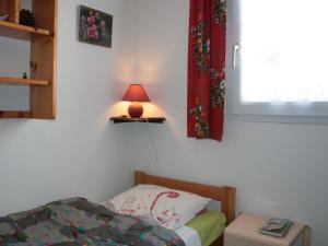 een kleine slaapkamer met een bed en een lamp bij Maison La Tranche-sur-Mer, 3 pièces, 4 personnes - FR-1-22-209 in La Tranche-sur-Mer