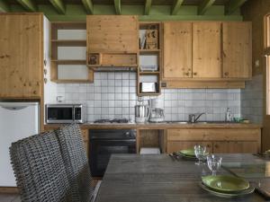 a kitchen with wooden cabinets and a wooden table at Gîte Jenzat, 3 pièces, 5 personnes - FR-1-489-260 in Jenzat