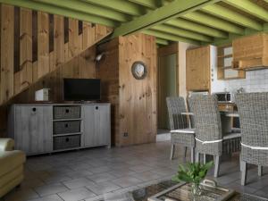 a living room with wooden walls and a table and chairs at Gîte charmant avec grand jardin, terrasse et wifi, proche Vichy, idéal famille et animaux bienvenus - FR-1-489-260 in Jenzat