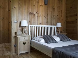 a bedroom with a bed and a wooden wall at Gîte charmant avec grand jardin, terrasse et wifi, proche Vichy, idéal famille et animaux bienvenus - FR-1-489-260 in Jenzat
