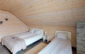 カルビアにある2 Bedroom Pet Friendly Home In Karwiaのベッド2台 木製の壁の部屋