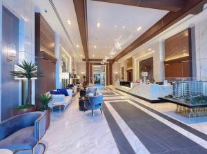 a lobby of a hotel with blue chairs and tables at Astra Sky River Pool By Duke 07 in Chiang Mai