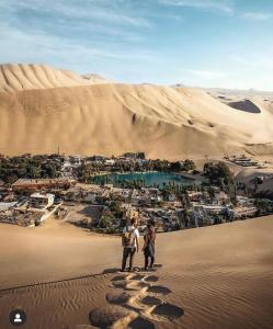 two people standing in the sand in the desert at Ica tierra del sol eterno 3 in Ica