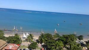 - Vistas a una playa con barcos en el agua en NA BEIRA MAR DE PAJUCARA - EDIFICIO NEO 2 - TEM VARANDA - VISTA LATERAL DO MAR- APARTAMENTO COM 02 QUARTOS - AVENIDA DOUTOR ANTONIO GOUVEIA 1081- CONSUMO ELETRICO É PAGO No CKECK-OUT 1KWH É 1,35 REIAS en Maceió