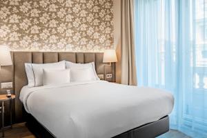 a bedroom with a large bed and a large window at Hotel Palacio del Retiro, Autograph Collection in Madrid