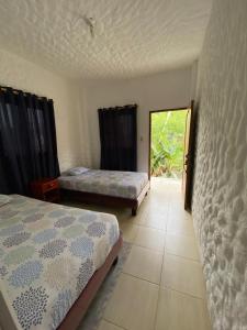a room with two beds and a door with a window at Casa de Heidi in Puerto López