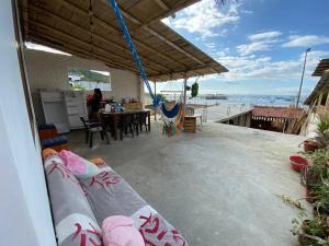 a patio with a table and chairs with a view of the ocean at Casa de Heidi in Puerto López