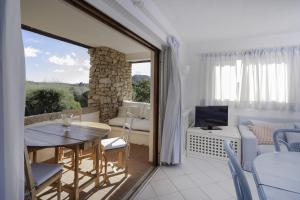 een woonkamer met een tafel en een televisie bij Sole&Luna Apartments in Porto Rotondo