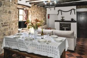 una mesa con mantel blanco y una botella de vino en 6 bedrooms villa with private pool furnished garden and wifi at Montefrio, en Montefrío