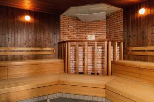 a sauna with wood paneling and a brick wall at Oriental Hotel Okinawa Resort & Spa in Nago